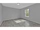 Bright bedroom with grey walls, wood-look floors and a window at 5389 Ocarina Rd, North Port, FL 34291