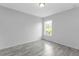 Simple bedroom with gray walls, wood-look tile floor, and a window at 5389 Ocarina Rd, North Port, FL 34291