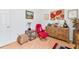 Bright home office features wood flooring, built-in shelving, and a comfortable red armchair at 5608 New Covington Dr, Sarasota, FL 34233