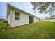Spacious backyard with grassy area and home exterior at 6049 Grand Cypress Blvd, North Port, FL 34287