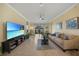 Bright living room with large TV, comfy sofa, and access to backyard at 6049 Grand Cypress Blvd, North Port, FL 34287