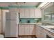 White kitchen cabinets, light blue walls, and modern appliances at 6305 Parkview Ct, North Port, FL 34287