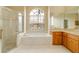 Elegant bathroom with a large soaking tub, shower, and wood cabinets at 632 Balsam Apple Dr, Venice, FL 34293