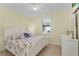 Bedroom with white bed, yellow walls, and floral bedding at 1002 Messina Dr, Punta Gorda, FL 33950