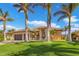 Tan house with brown garage doors, landscaping, and palm trees at 1002 Messina Dr, Punta Gorda, FL 33950