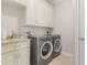 Bright laundry room with washer, dryer and upper cabinets at 1002 Messina Dr, Punta Gorda, FL 33950