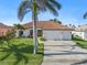 White two-story house with tile roof, three-car garage, and lush landscaping at 11 Sabal Dr, Punta Gorda, FL 33950