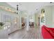 Bright living room with light walls, wood floors, and a red couch at 124 Beau Rivage Dr, Rotonda West, FL 33947