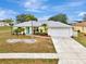 Single-story house with a two-car garage, landscaping, and palm trees at 13284 Buckett Cir, Port Charlotte, FL 33981