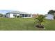 Large backyard with green grass, palm tree, and home view at 13323 Copper Ave, Port Charlotte, FL 33981