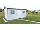 White storage shed with gray trim in the backyard at 13323 Copper Ave, Port Charlotte, FL 33981