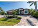 Stunning curb appeal! This home features a tile roof, paver driveway, and lush landscaping at 1406 Mediterranean Dr, Punta Gorda, FL 33950