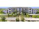 Exterior of a light blue condominium building with palm trees and covered parking at 14091 Heritage Landing Blvd # 121, Punta Gorda, FL 33955