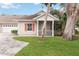 Exterior view of villa with attached garage and screened porch at 1433 Red Oak Ln, Port Charlotte, FL 33948