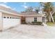 Exterior view of villa with attached garage and screened porch at 1433 Red Oak Ln, Port Charlotte, FL 33948