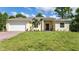 Single-story home with a white garage door and a neatly landscaped lawn at 14386 San Domingo Blvd, Port Charlotte, FL 33981