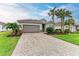 House exterior featuring a paved driveway and a well-maintained lawn at 15169 Spanish Point Dr, Port Charlotte, FL 33981