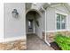 Inviting front entry with stone accents and a charming welcome sign at 15169 Spanish Point Dr, Port Charlotte, FL 33981