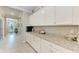 Bright laundry room with white cabinets and granite countertops at 15169 Spanish Point Dr, Port Charlotte, FL 33981