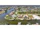 Aerial view showcasing a canal-front house with a pool and dock at 15706 Viscount Cir, Port Charlotte, FL 33981