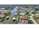 An aerial view of a waterfront property with a pool and boat dock at 15706 Viscount Cir, Port Charlotte, FL 33981