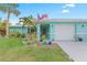 Front view of a teal house with American flag and landscaped yard at 1638 Viscaya Dr, Port Charlotte, FL 33952