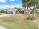 Single-story home with two palm trees and a landscaped yard at 18305 Wolbrette Cir, Port Charlotte, FL 33948