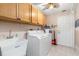 Bright laundry room with washer, dryer, cabinets, and utility sink at 18305 Wolbrette Cir, Port Charlotte, FL 33948