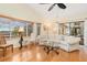 Sunlit living room showcasing hardwood floors, bay window, and curved sofa at 18305 Wolbrette Cir, Port Charlotte, FL 33948