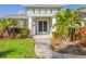 Front entrance of the house with columns, double doors, and lush landscaping at 1966 Trout Cir, Englewood, FL 34224