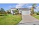 One-story home with light gray exterior and palm trees at 1966 Trout Cir, Englewood, FL 34224