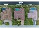 Aerial view of three houses with pools, lush landscaping, and canal access at 2064 El Cerito Ct, Punta Gorda, FL 33950