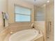 Relaxing bathroom with soaking tub, shower, and neutral tile at 2064 El Cerito Ct, Punta Gorda, FL 33950