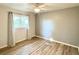 Bright bedroom featuring hardwood floors, neutral paint, a ceiling fan, and a large window at 21217 Knollwood Ave, Port Charlotte, FL 33952