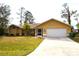 Bright yellow house with a two-car garage and well-manicured lawn at 21217 Knollwood Ave, Port Charlotte, FL 33952