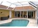 Enclosed kidney shaped pool with patio furniture and dining area at 21217 Knollwood Ave, Port Charlotte, FL 33952