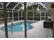 Kidney-shaped pool with screened enclosure at 21217 Knollwood Ave, Port Charlotte, FL 33952