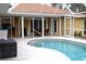 View of the in-ground screened pool and covered patio area, with outdoor seating at 21217 Knollwood Ave, Port Charlotte, FL 33952