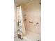 A tiled shower with a curtain, shelving and safety bar at 21217 Knollwood Ave, Port Charlotte, FL 33952