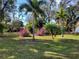 Landscaped backyard with tropical plants and lush green grass at 21217 Knollwood Ave, Port Charlotte, FL 33952