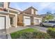 Tan two-story townhome with attached two-car garage and landscaping at 240 W End Dr # 212, Punta Gorda, FL 33950