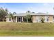 Tan house with gray roof, landscaping, and screened porch at 2411 Altoona Ave, North Port, FL 34286