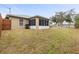 Back exterior view of home showcasing landscaping and screened patio at 2411 Altoona Ave, North Port, FL 34286