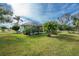 Backyard with lush lawn, screened enclosure, and tropical plants at 24434 Rio Togas Rd, Punta Gorda, FL 33955