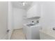 Bright laundry room with washer, dryer, and ample shelving at 24434 Rio Togas Rd, Punta Gorda, FL 33955