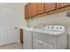 Laundry room with washer, dryer, and wooden cabinets at 2476 Daisy Dr, North Port, FL 34289