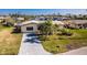 Aerial view of a single Gathering home with driveway and green lawn at 3200 Colony Ct, Punta Gorda, FL 33950