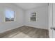 Bright bedroom featuring wood-look floors and two windows at 3740 Easy St, Port Charlotte, FL 33952