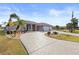 Beautiful home features a spacious three-car garage and a patterned concrete driveway with lush tropical landscaping at 4122 Library St, Port Charlotte, FL 33948