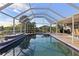 Relaxing pool area with screened enclosure, patio, and water views at 4122 Library St, Port Charlotte, FL 33948